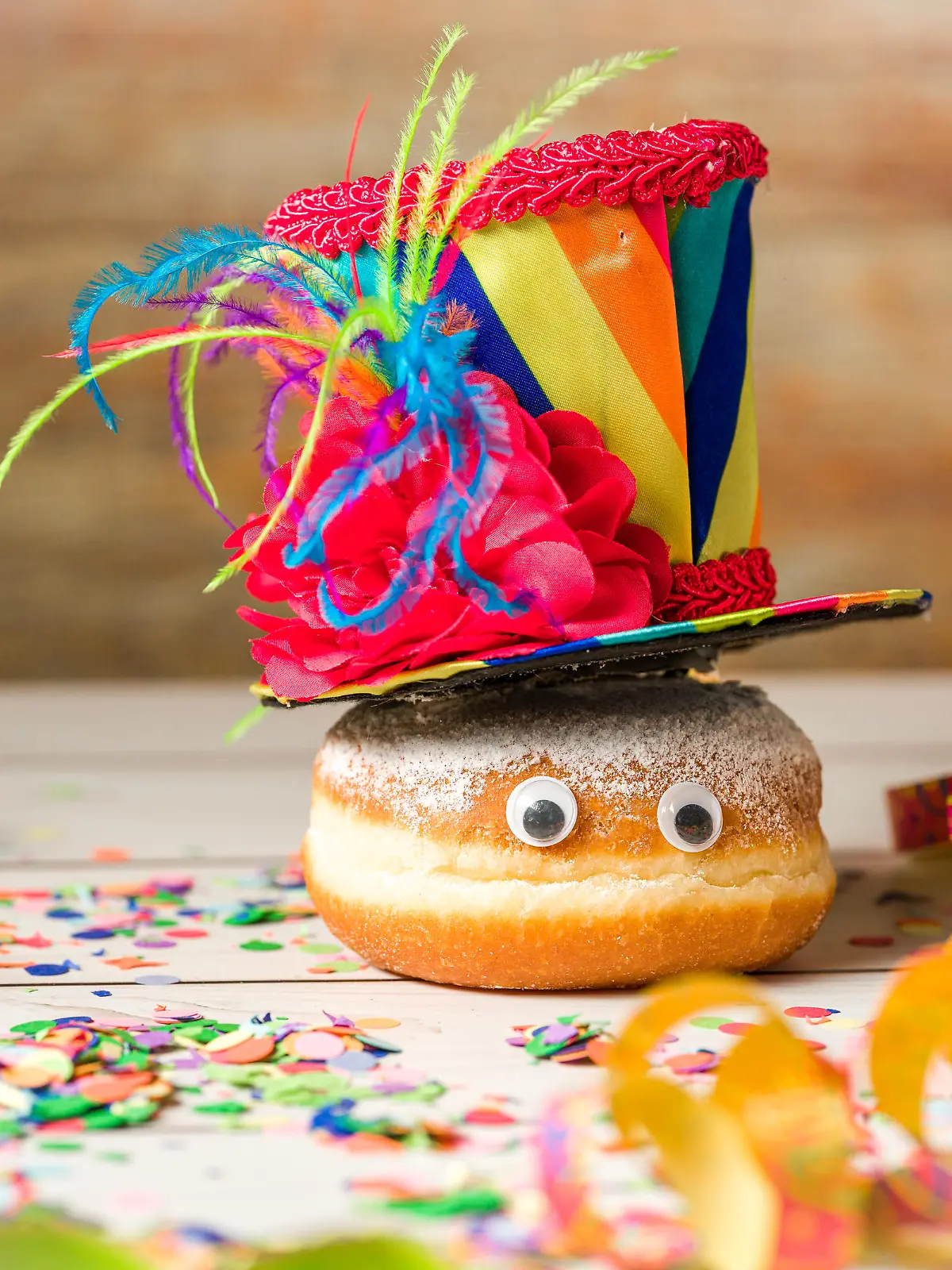 Bavaria, Germany - 02 February 2023: Berliner doughnut decorated for Shrove Monday, Carnival or Carnival with streamers, costume and confetti *** Krapfen Berliner dekoriert zu Rosenmontag, Fasching oder Karneval mit Luftschlangen, Kostüm und Konfetti / 020223