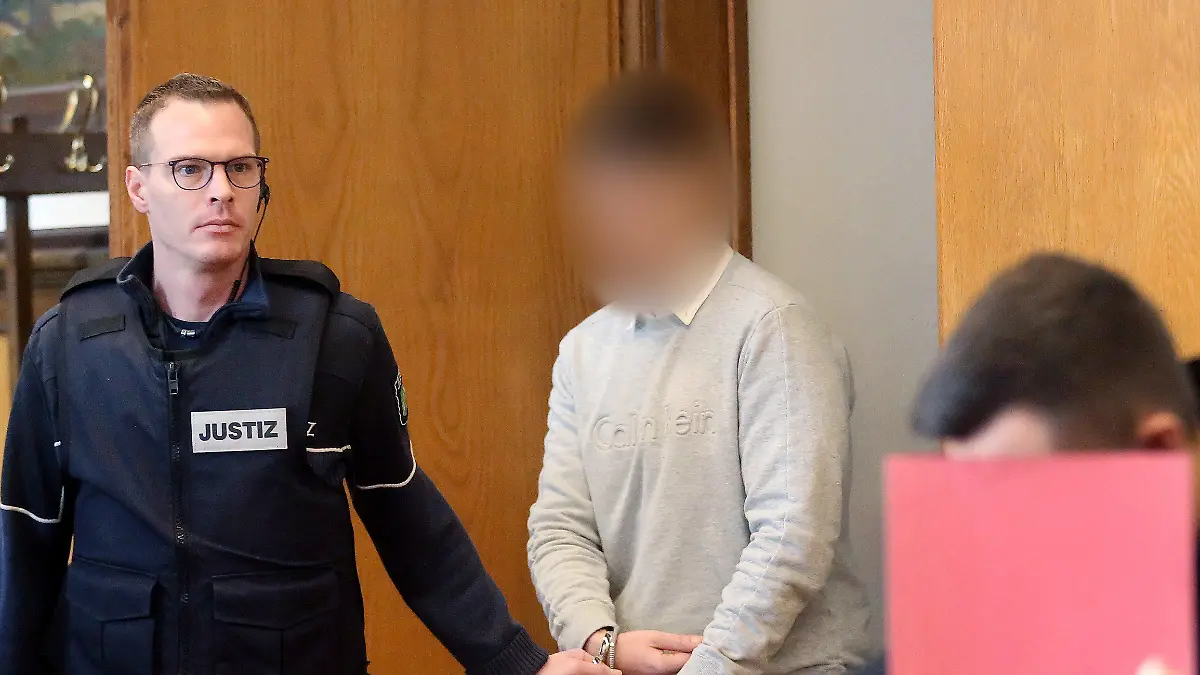 17.02.2020, Nordrhein-Westfalen, Kleve: Der Hauptangeklagte (2.v.l) wird von einem Justizbeamten am Mitangeklagten (r) vorbei zur Anklagebank gebracht. Den Angeklagten wird vorgeworfen, ein verbotenes Autorennen in Moers veranstaltet zu haben. Einer der beiden stieß mit dem Wagen einer unbeteiligten Frau zusammen, die drei Tage später starb. Foto: Roland Weihrauch/dpa - ACHTUNG: Angeklagter auf Anweisung des Gerichts gepixelt +++ dpa-Bildfunk +++