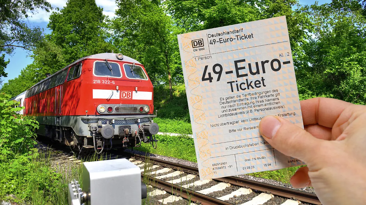 FOTOMONTAGE, Hand hält 49-Euro-Ticket vor Regionalbahn, Symbolfoto *** PHOTOMONTAGE, hand holding 49 euro ticket in front of regional train, symbol photo