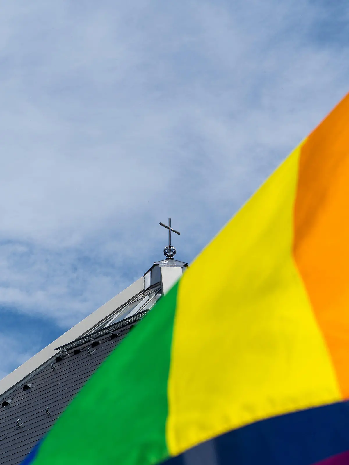 ARCHIV - 09.05.2021, Baden-Württemberg, Baden-Baden: Eine Regenbogenfahne weht vor der Autobahnkirche St. Christophorus am Rande der Segnung von gleichgeschlechtlichen Paaren. Ab März 2026 wird es in der katholischen Kirche in Deutschland offizielle Segensfeiern für homosexuelle Paare geben. Das hat die Synodalversammlung zur Reform der katholischen Kirche am Freitag in Frankfurt/Main beschlossen. Foto: Benedikt Spether/dpa +++ dpa-Bildfunk +++