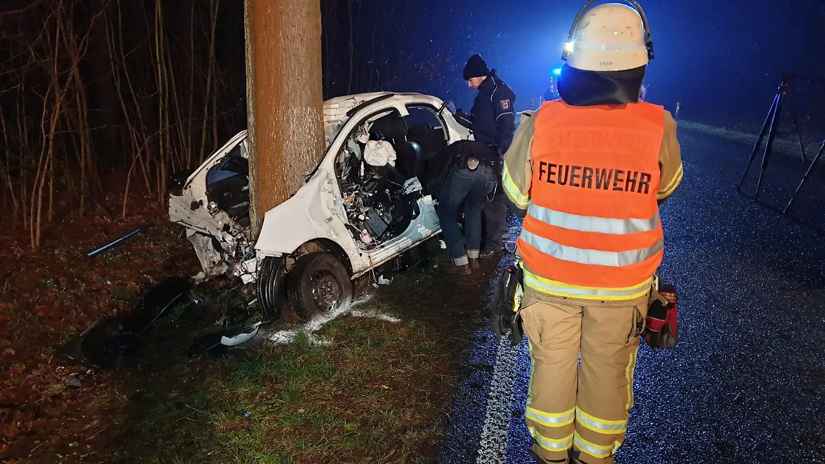 14.02.2020, Brandenburg, Baruth: Zwei Polizisten und ein Feuerwehrmann stehen neben einem stark beschädigten Auto. Eine 22 Jahre alte Autofahrerin ist bei einem Unfall im Landkreis Teltow-Fläming ums Leben gekommen. Foto: Julian Stähle/dpa-Zentralbild/dpa +++ dpa-Bildfunk +++