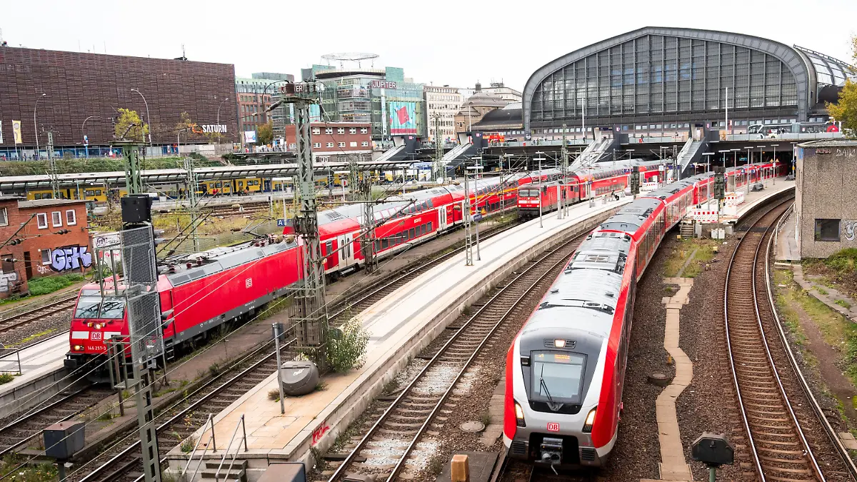 ARCHIV - 03.11.2022, Hamburg: Eine S-Bahn fährt aus dem Hauptbahnhof aus. Daneben stehen zwei Regionalzüge der Deutschen Bahn. Bei den bevorstehenden Tarifverhandlungen für die Beschäftigten der Deutschen Bahn ist eine hartes Ringen zu erwarten. Bereits in der ersten Runde will die Gewerkschaft EVG ein Angebot sehen - sonst drohen Warnstreiks mit Stillstand für die Fahrgäste. (zu dpa «Bahn und Gewerkschaft EVG vor harter Tarifrunde») Foto: Daniel Bockwoldt/dpa +++ dpa-Bildfunk +++