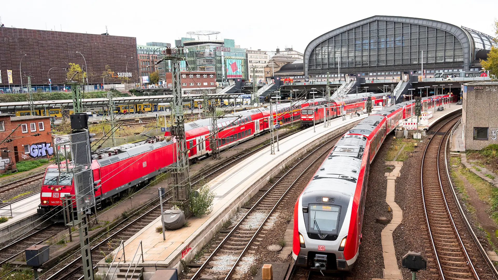 ARCHIV - 03.11.2022, Hamburg: Eine S-Bahn fährt aus dem Hauptbahnhof aus. Daneben stehen zwei Regionalzüge der Deutschen Bahn. Bei den bevorstehenden Tarifverhandlungen für die Beschäftigten der Deutschen Bahn ist eine hartes Ringen zu erwarten. Bereits in der ersten Runde will die Gewerkschaft EVG ein Angebot sehen - sonst drohen Warnstreiks mit Stillstand für die Fahrgäste. (zu dpa «Bahn und Gewerkschaft EVG vor harter Tarifrunde») Foto: Daniel Bockwoldt/dpa +++ dpa-Bildfunk +++