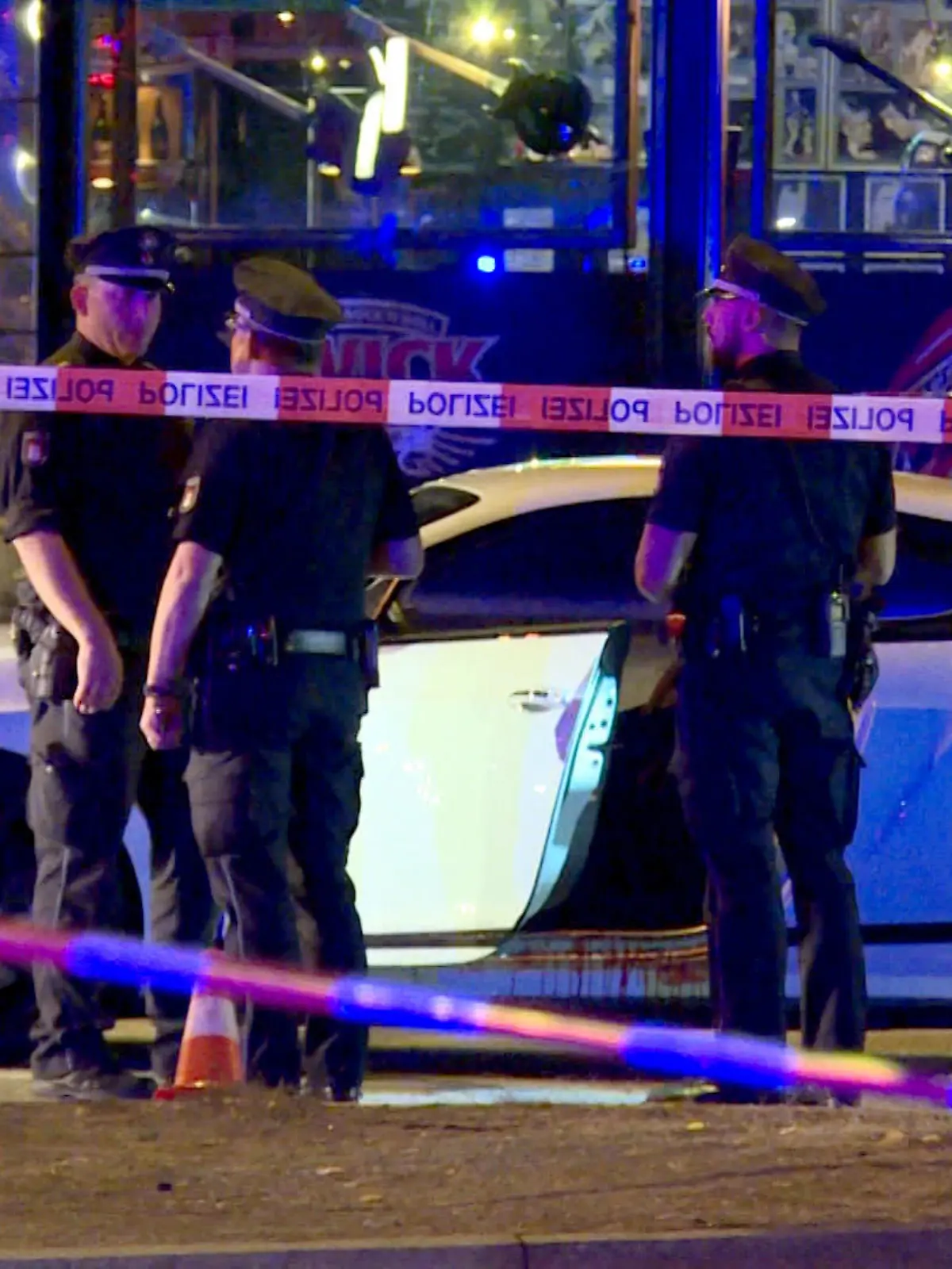 ARCHIV - 27.08.2018, Hamburg: Polizisten stehen neben einem Auto auf dem Millerntorplatz an der Reeperbahn, nachdem Schüsse gefallen waren. Der spektakuläre Prozess gegen einen Mann, der aus dem Gefängnis heraus den Mord an einem Rockerboss in Hamburg in Auftrag gegeben haben soll, wird vom 06.02.2020 an neu aufgerollt. Dann beginnt nicht nur die neuerliche Hauptverhandlung gegen den 29 Jahre alten Angeklagten, sondern auch der Prozess gegen dessen 73-jährigen Vater sowie einen 27-jährigen Bulgaren. Foto: Mücahid Güler/dpa +++ dpa-Bildfunk +++
