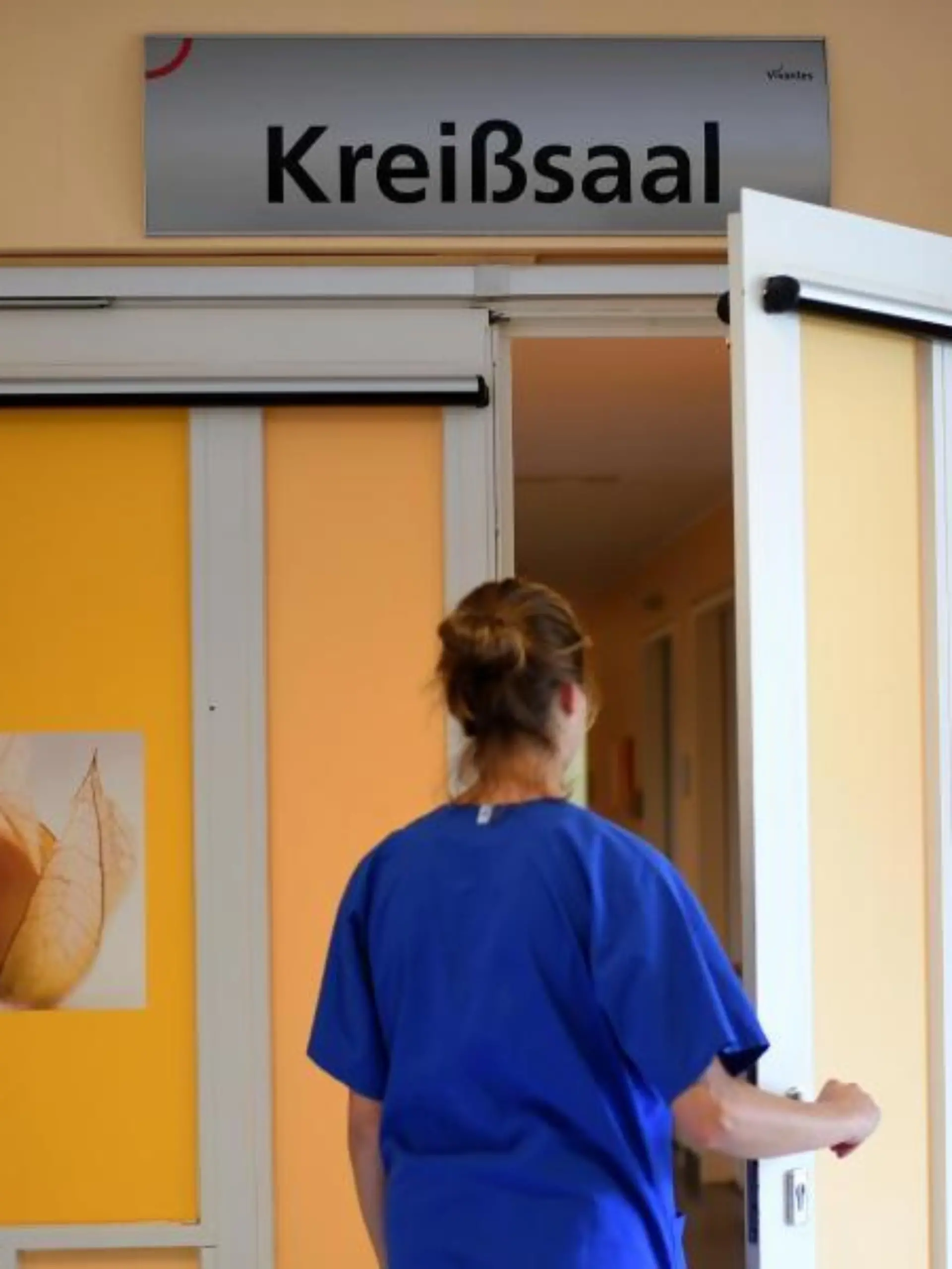 Eine Hebamme vor dem Kreißsaal