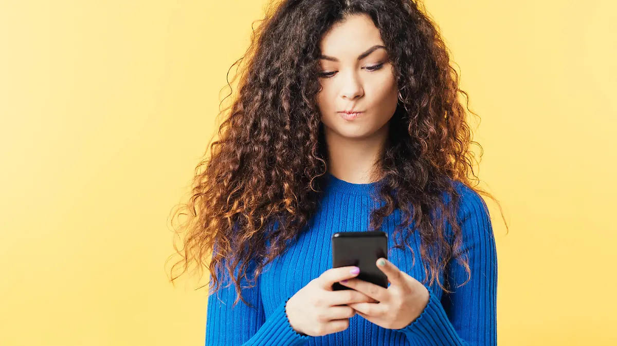 Frau guckt fragend auf ihr Smartphone.