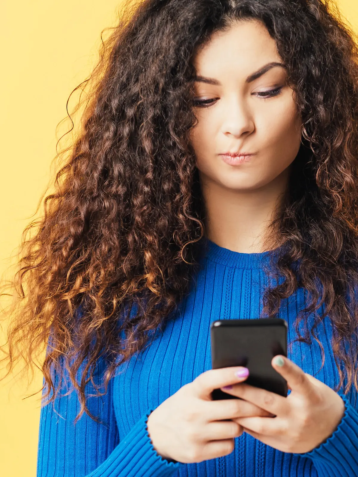 Frau guckt fragend auf ihr Smartphone.