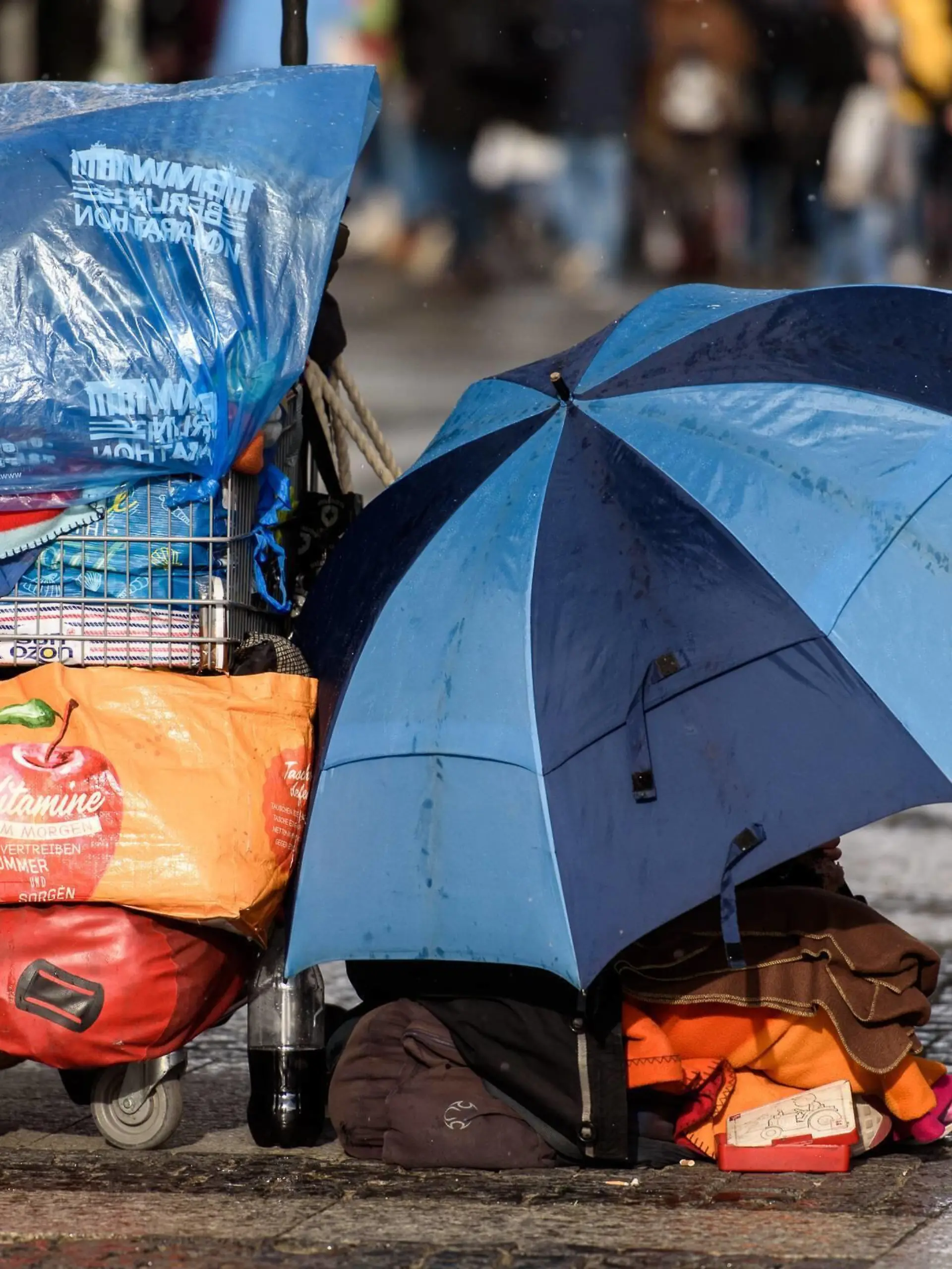  Feature Bild Obdachlosigkeit Deutschland, Berlin - 09/03/2019: Im Bild ist ein Obdachloser Mensch mit Schirm und Einkaufswagen sitzend auf der Straße zu sehen. Berlin Berlin Deutschland *** Feature Picture Homelessness Germany Berlin 09 03 2019 The picture shows a homeless person sitting on the street with an umbrella and a shopping trolley Berlin Berlin Berlin Germany