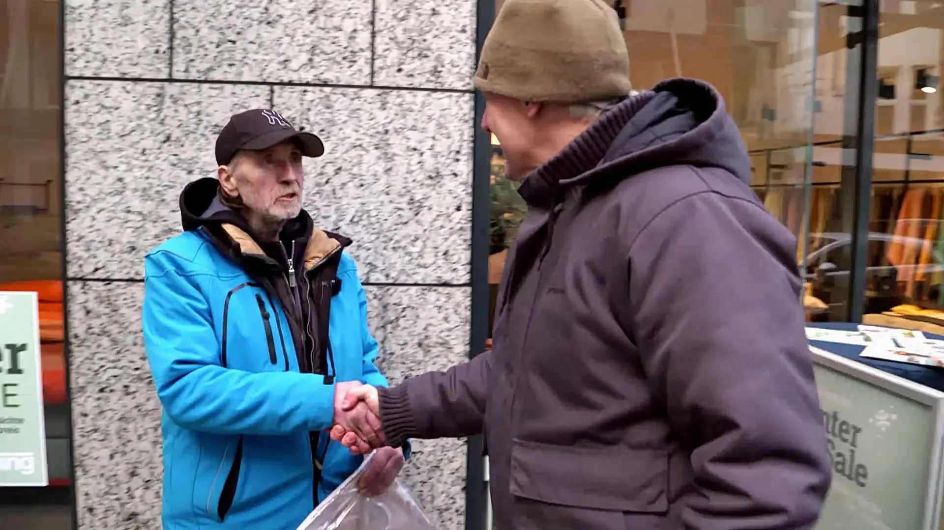 Streetworker Oliver Ongaro reicht einem Mann die Hand.