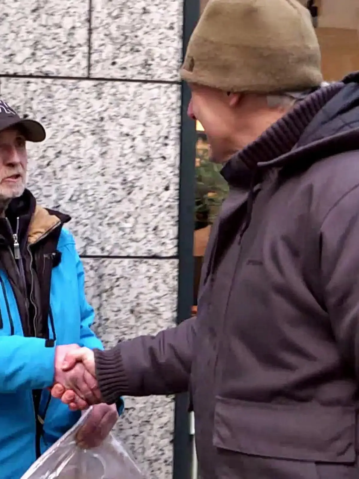 Streetworker Oliver Ongaro reicht einem Mann die Hand.