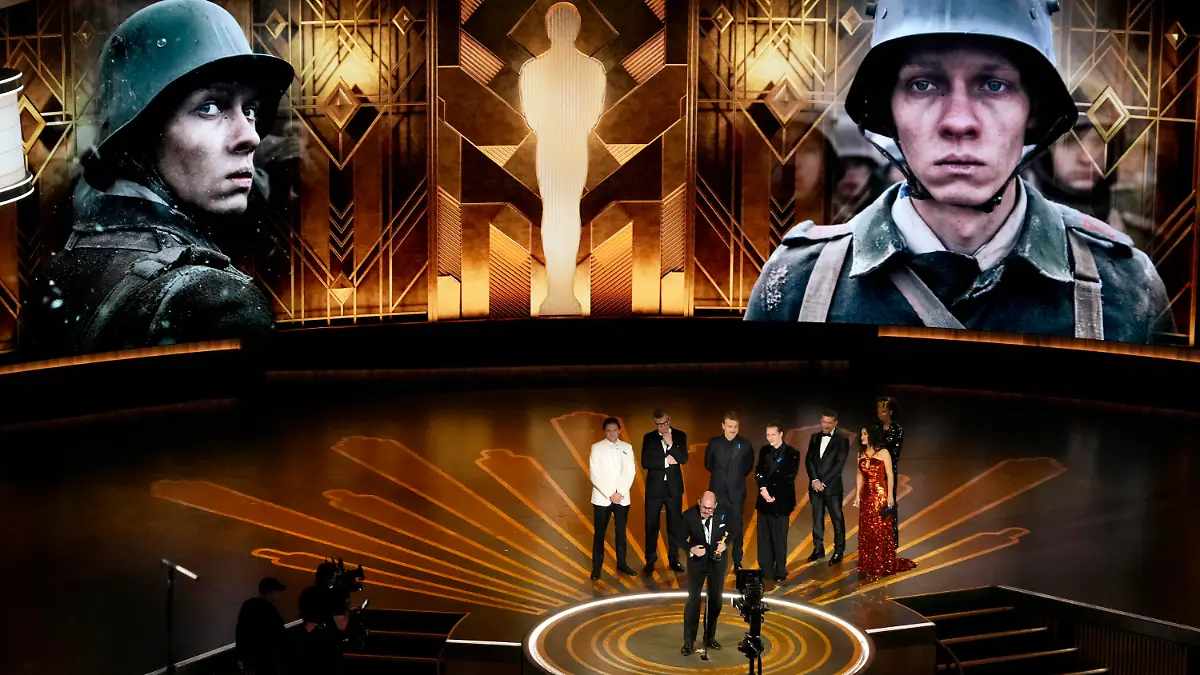 12.03.2023, USA, Los Angeles: Regisseur Edward Berger (vorne) nimmt den Preis für  «Im Westen nichts Neues» aus Deutschland für den besten internationalen Spielfilm bei der Oscar-Vverleihung im Dolby Theatre in Los Angeles entgegen. Hinten stehen Daniel Brühl (l-r), Malte Grunert, Albrecht Schuch, Felix Kammerer, Antonio Banderas und Salma Hayek. Foto: Chris Pizzello/Invision/AP +++ dpa-Bildfunk +++