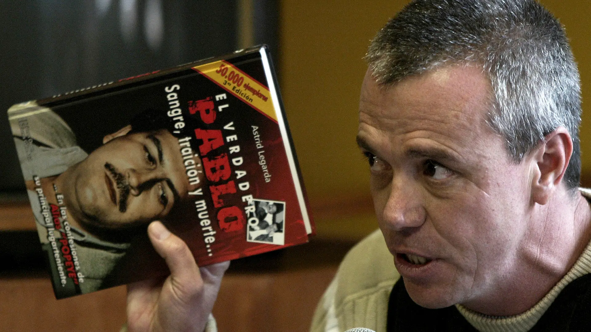 ARCHIV - 10.12.2017, Kolumbien, Bogota: Jhon Jairo Velasquez, ehemaliger Auftragskiller des ehemaligen Drogenbosses Escobar, hält ein Buch mit dem Titel «The true life of Pablo Escobar: Blood, betrayal and death» (Der wahre Pablo, Blut, Verrat und Tod). Velasquez ist in Kolumbien gestorben. Das teilte das Nationale Gefängnis- und Haftinstitut INPEC mit. Foto: William Fernando Martinez/AP/dpa +++ dpa-Bildfunk +++