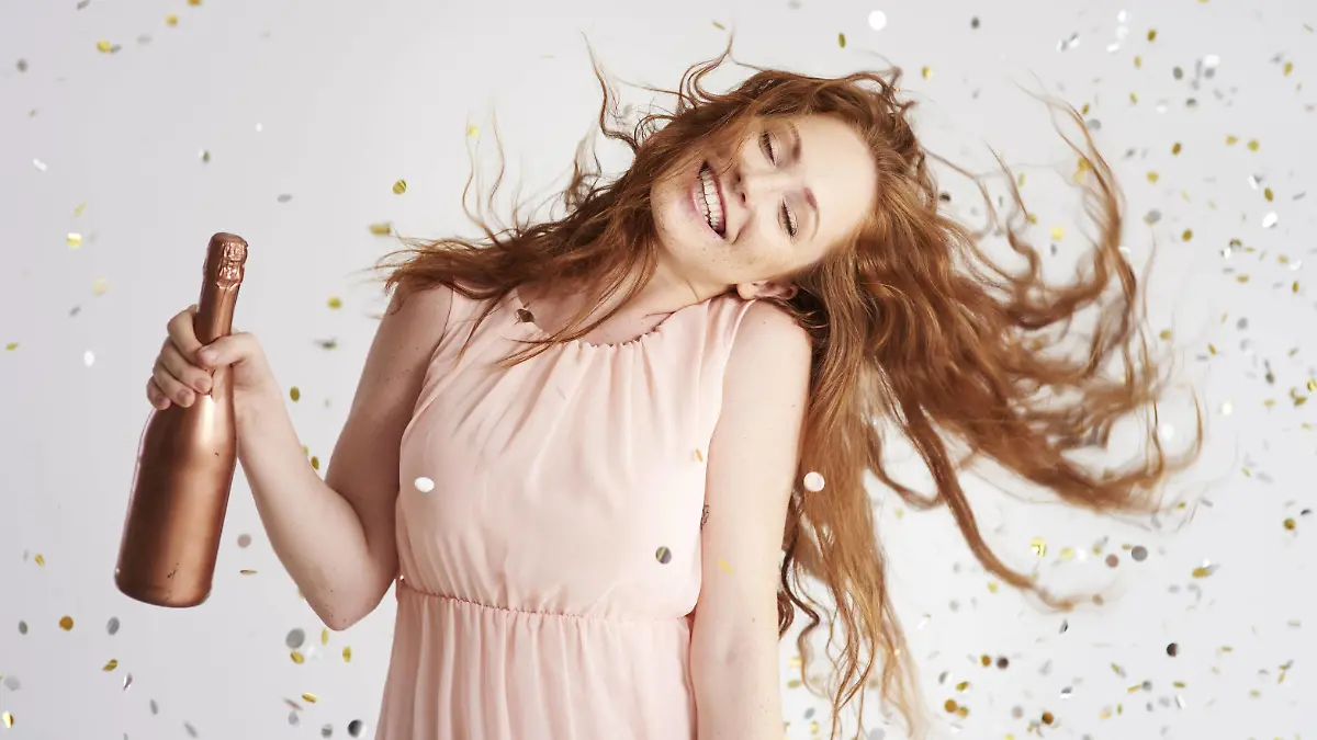 Portrait of happy young woman dancing with bottle of champagne model released Symbolfoto PUBLICATIONxINxGERxSUIxAUTxHUNxONLY ABIF00888  