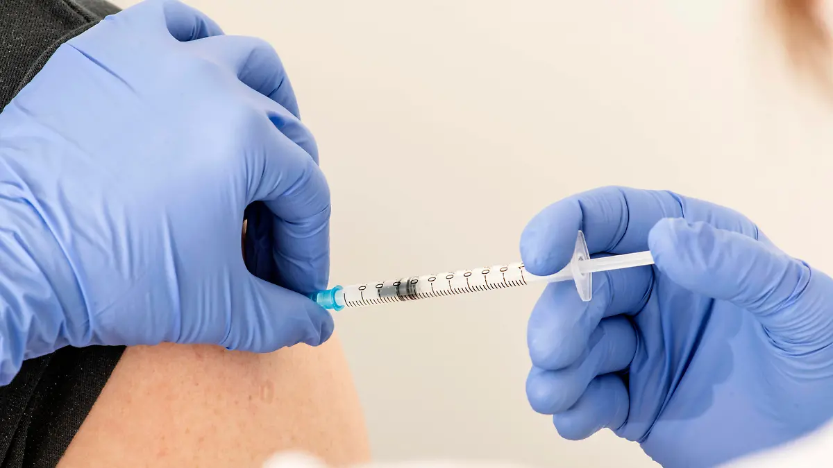 Ärztin setzt Spritze in den Oberarm, Boosterung mit Biontech, Planegg bei München, 25. Januar 2022 DEU, Deutschland, Planegg bei München, 25.01.2022, Ärztin impft einen Patienten, setzt Impf-Spritze mit Biontech in den Oberarm, Boosterung, Drittimpfung, vorher: ärztliche Beratung, Arztpraxis, Injektion, Coronaimpfung, Symbol Impfkampagne, 7-Tage Inzidenz für München über 1500, Omikron, Coronawelle, Coronakrise, Pandemie, COVID-19, Bayern, Januar 2022, Querformat, *** Doctor places syringe in upper arm, boosting with Biontech, Planegg near Munich, 25 January 2022 DEU, Germany, Planegg near Munich, 25 01 2022, doctor vaccinates a patient, places vaccination syringe with Biontech in upper arm, Booster, third vaccination, previous medic