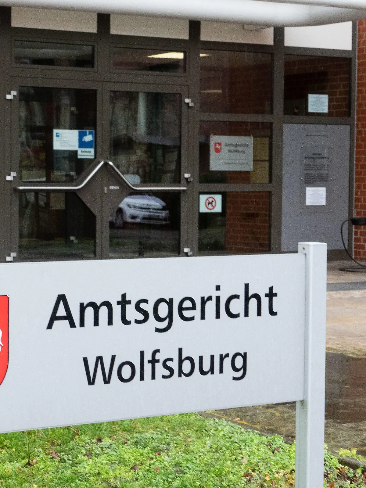 03.02.2020, Niedersachsen, Wolfsburg: Ein Schild steht vor dem Amtsgericht Wolfsburg. Vor dem Amtsgericht beginnt ein Prozess gegen vier Betreuerinnen, denen fahrlässige Tötung vorgeworfen wird. Sie sollen erst nach mindestens 30 Minuten bemerkt haben, dass ein kleiner Junge in etwa 30 Metern Entfernung in ein Regenrückhaltebecken gefallen war. Das Kind wurde in eine Klinik gebracht, wo es zwölf Tage später an Hirnschäden durch Ertrinken starb. Foto: David Hutzler/dpa +++ dpa-Bildfunk +++