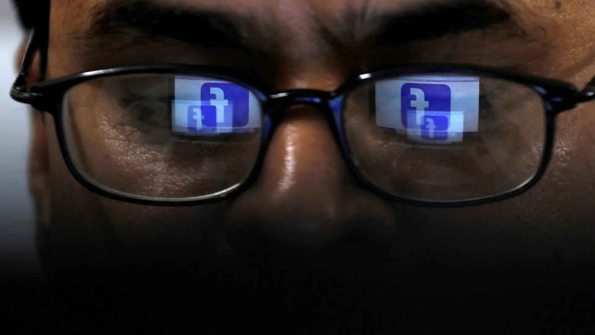 FILE PHOTO: Facebook logo is reflected in glasses in this picture illustration taken April 1, 2019. REUTERS/Akhtar Soomro/Illustration/File Photo
