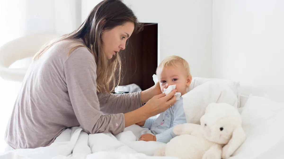Mutter putzt kleinem Jungen die Nase.