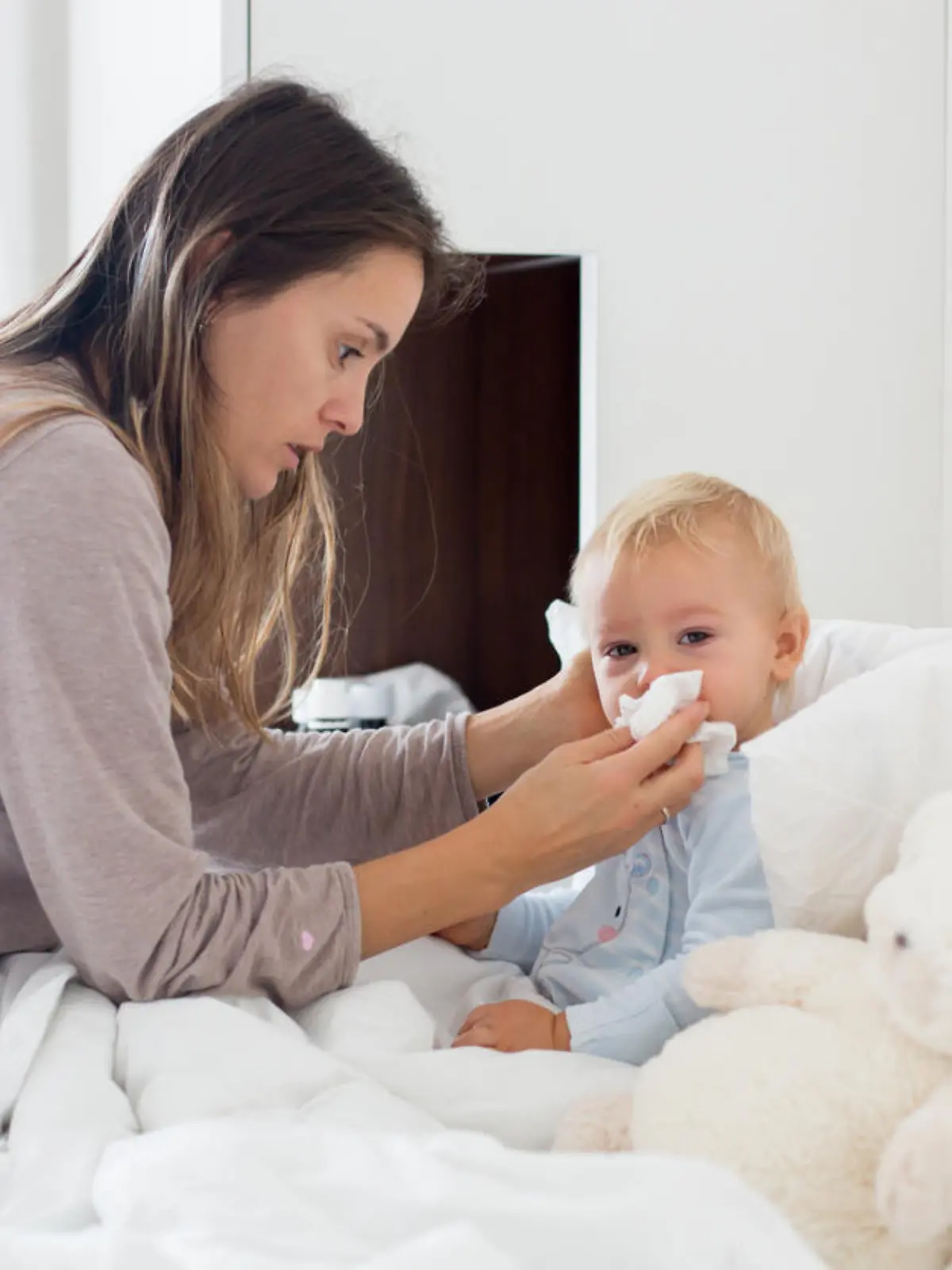 Mutter putzt kleinem Jungen die Nase.