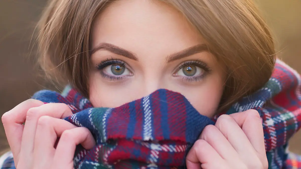 Portrait of a beautiful young woman with face wrapped with a plaid scarf.