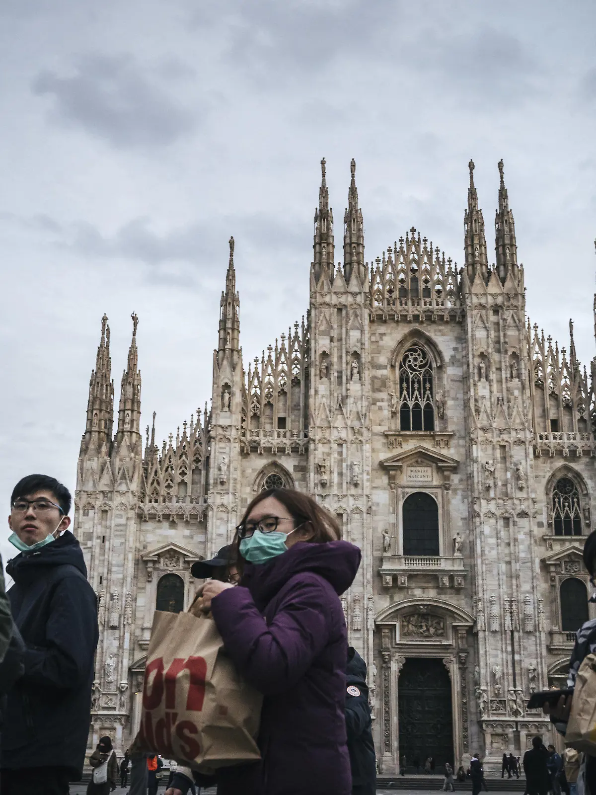 27.02.2020, Italien, Mailand: Touristen tragen Schutzmasken vor dem Mailänder Dom. Der Ausbruch des Coronavirus beeinträchtig den Tourismus des Landes. Foto: Valeria Ferraro/SOPA Images via ZUMA Wire/dpa +++ dpa-Bildfunk +++