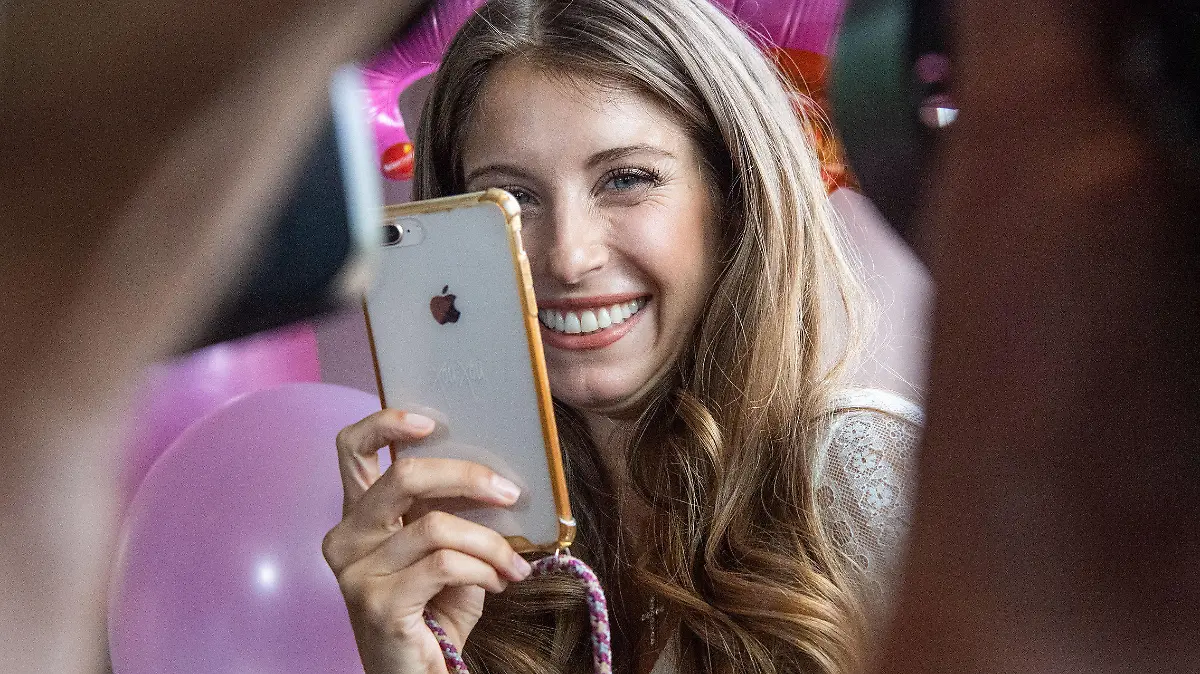 ARCHIV - 15.07.2019, Bayern, München: Cathy Hummels, Influencerin, steht mit einem Handy im selbst designten Dirndl vor Fotografen. Am 14.11.2019 wird der  4. Deutsche Bloggerpreis verliehen. Hummels soll die Veranstaltung moderieren. Foto: Lino Mirgeler/dpa +++ dpa-Bildfunk +++
