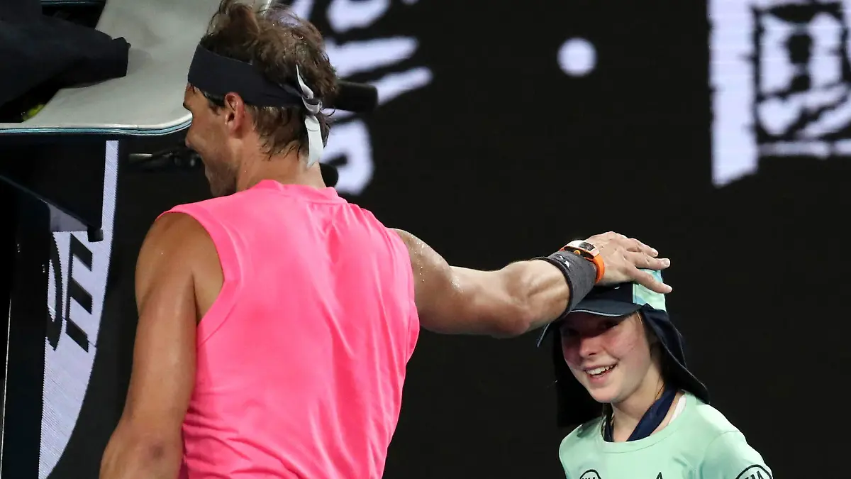 23.01.2020, Australien, Melbourne: Tennis: Grand Slam, ATP-Tour, Australian Open, Einzel, Herren, 2. Runde, Nadal (Spanien) - Delbonis (Argentinien). Rafael Nadal aus Spanien tätschelt einem Ballmädchen den Kopf, nachdem sie während des Spiels von einem Ball getroffen wurde. Foto: Dita Alangkara/AP/dpa +++ dpa-Bildfunk +++