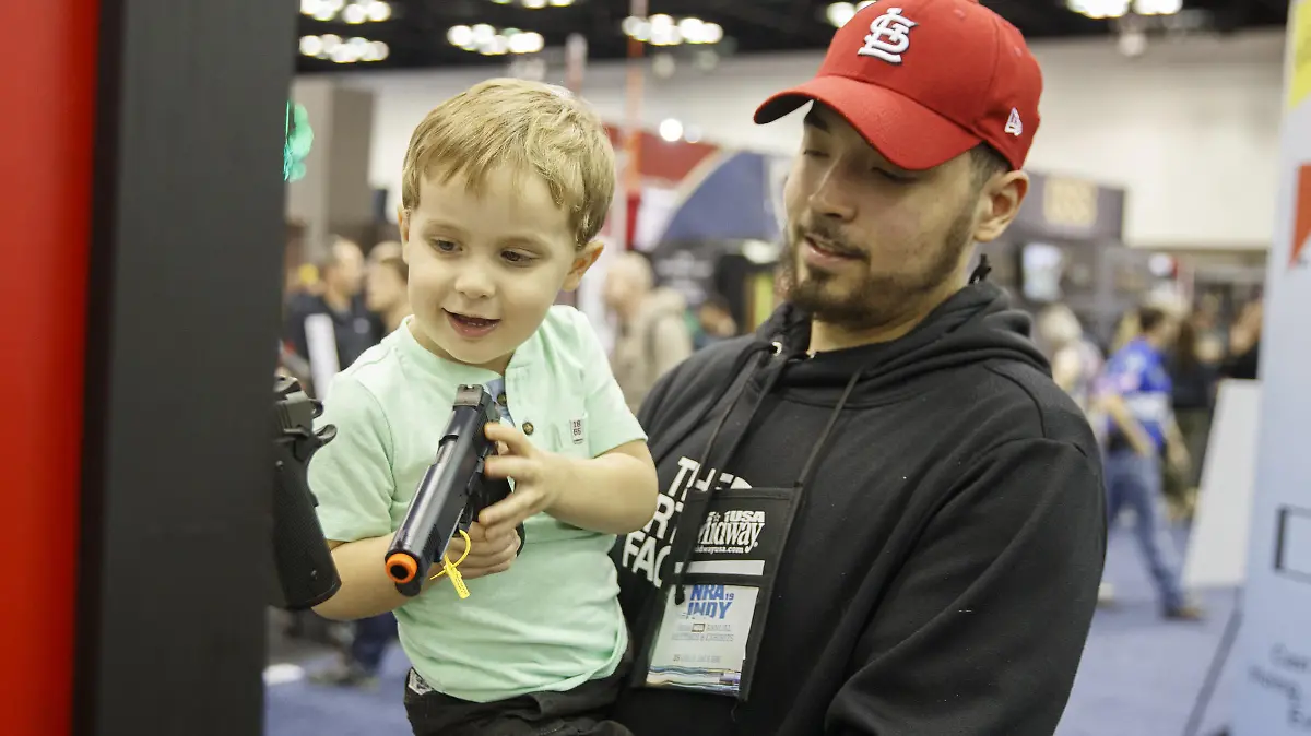 April 26, 2019 - Indianapolis, Indiana, United States - A little boy picks puts a handgun back on a rack at a booth during the National Rifle Association's national convention. (Credit Image: © Jeremy Hogan/SOPA Images via ZUMA Wire