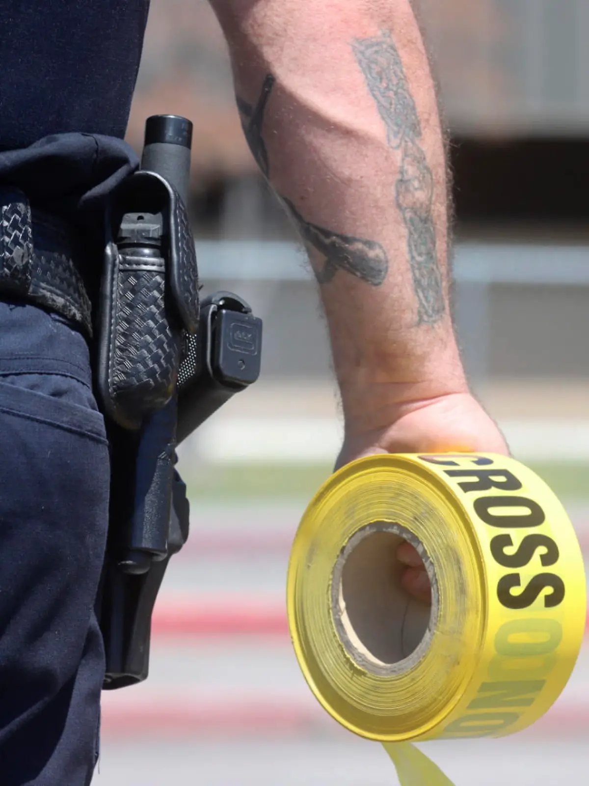 A police officer puts away a roll of tape outside Rigby Middle School following a shooting there earlier Thursday, May 6, 2021, in Rigby, Idaho. Authorities said that two students and a custodian were injured, and a female student has been taken into custody. (AP Photo/Natalie Behring)