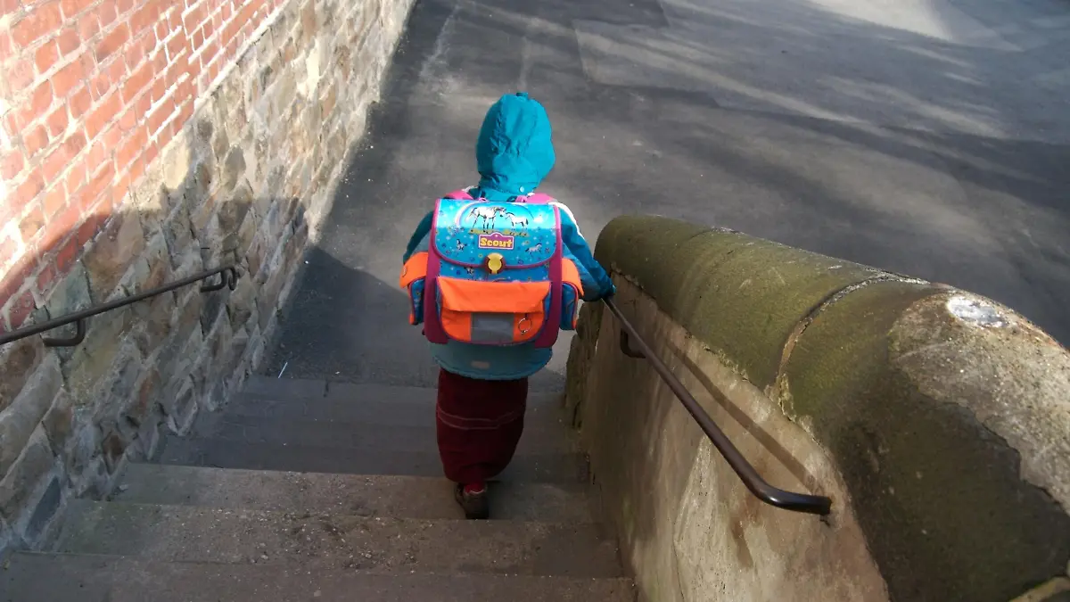 Die Katholische Grundschule 'Passstrasse' ist seit 2005 offene Ganztagsschule. Die Kinder werden auch nach dem Unterricht von Lehrern und pädagogischen Fachkräften betreut. Hier: ein Mädchen mit Schulranzen verlässt die Schule über eine Treppe und macht sich auf den Weg nach Hause. Aachen, Nordrhein-Westfalen, Deutschland, 14.01.2008