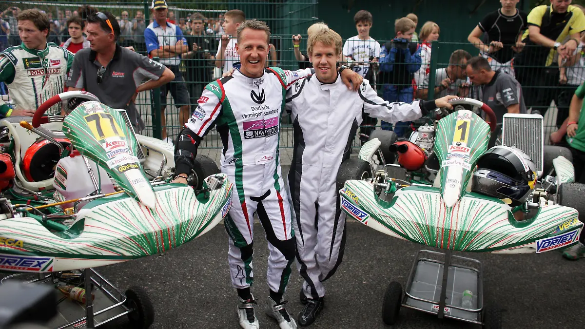 Die Formel-1-Piloten Sebastian Vettel (r) und Michael Schumacher stehen am Mittwoch (24.08.2011) auf der Rennbahn vom Kart-Club Kerpen in Kerpen-Manheim zwischen zwei Karts. Vettel und Schumacher nahmen an der Feier zum 50-jährigen Jubiläum des Clubs teil. Foto: Rolf Vennenbernd dpa/lnw  +++(c) dpa - Bildfunk+++