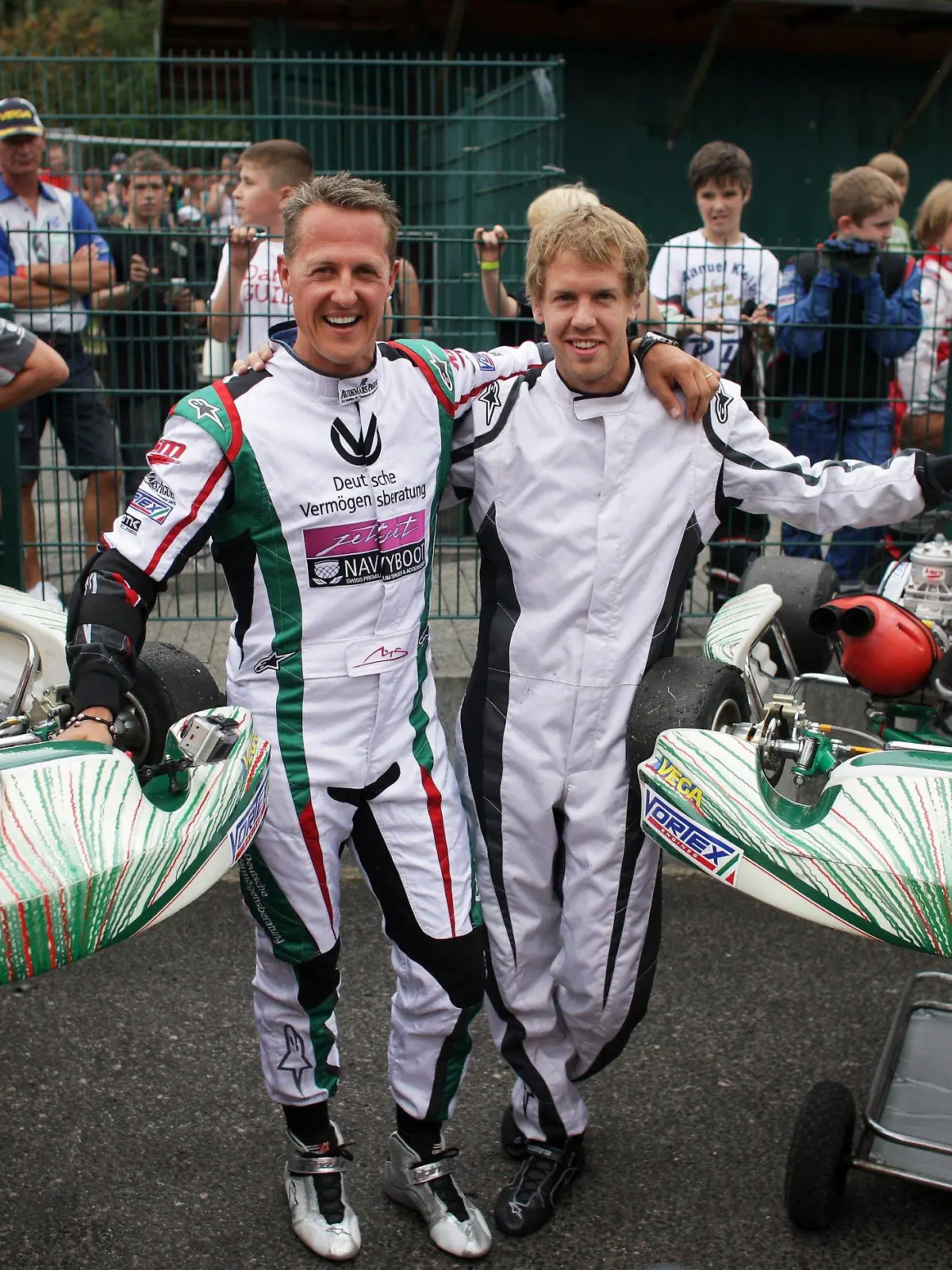 Die Formel-1-Piloten Sebastian Vettel (r) und Michael Schumacher stehen am Mittwoch (24.08.2011) auf der Rennbahn vom Kart-Club Kerpen in Kerpen-Manheim zwischen zwei Karts. Vettel und Schumacher nahmen an der Feier zum 50-jährigen Jubiläum des Clubs teil. Foto: Rolf Vennenbernd dpa/lnw  +++(c) dpa - Bildfunk+++