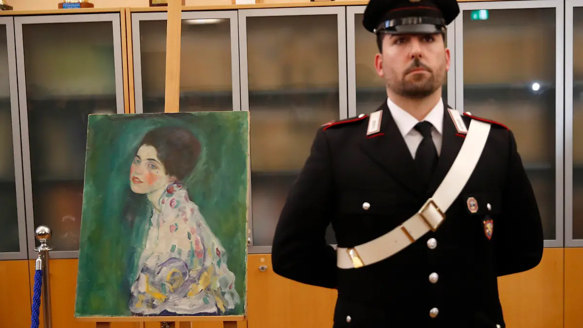 17.01.2020, Italien, Piacenza: Ein italienischer Carabiniere steht neben einem Gemälde, das im Dezember 2019 in der Nähe einer Kunstgalerie gefunden wurde. Zwei mutmaßliche Diebe des Gemäldes des Jugendstilmalers Gustav Klimt haben sich in Italien gestellt. Sie hätten sich gegenüber einer Lokalzeitung selbst beschuldigt, bestätigte die Polizei in der Stadt Piacenza der Deutschen Presse-Agentur. (zu dpa "Wiederentdeckter Klimt: Mutmaßliche Diebe melden sich") Foto: Antonio Calanni/AP/dpa +++ dpa-Bildfunk +++