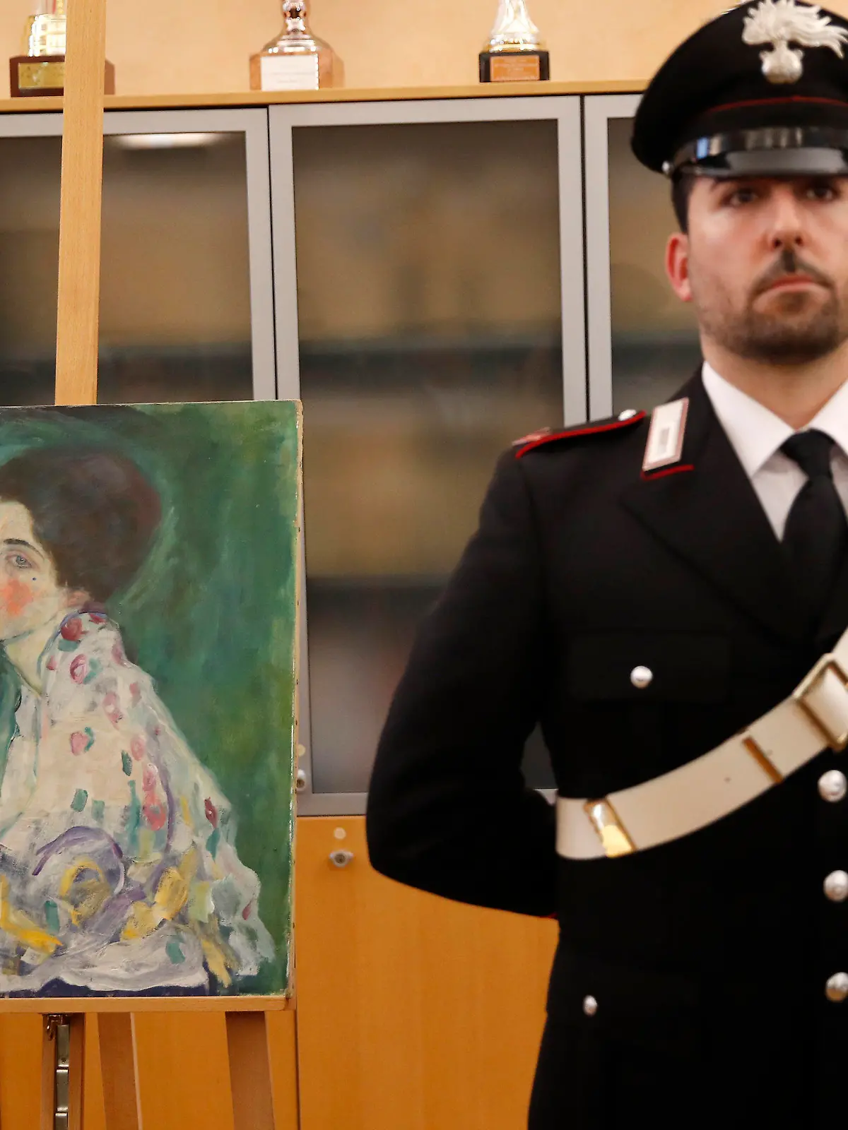 17.01.2020, Italien, Piacenza: Ein italienischer Carabiniere steht neben einem Gemälde, das im Dezember 2019 in der Nähe einer Kunstgalerie gefunden wurde. Zwei mutmaßliche Diebe des Gemäldes des Jugendstilmalers Gustav Klimt haben sich in Italien gestellt. Sie hätten sich gegenüber einer Lokalzeitung selbst beschuldigt, bestätigte die Polizei in der Stadt Piacenza der Deutschen Presse-Agentur. (zu dpa "Wiederentdeckter Klimt: Mutmaßliche Diebe melden sich") Foto: Antonio Calanni/AP/dpa +++ dpa-Bildfunk +++
