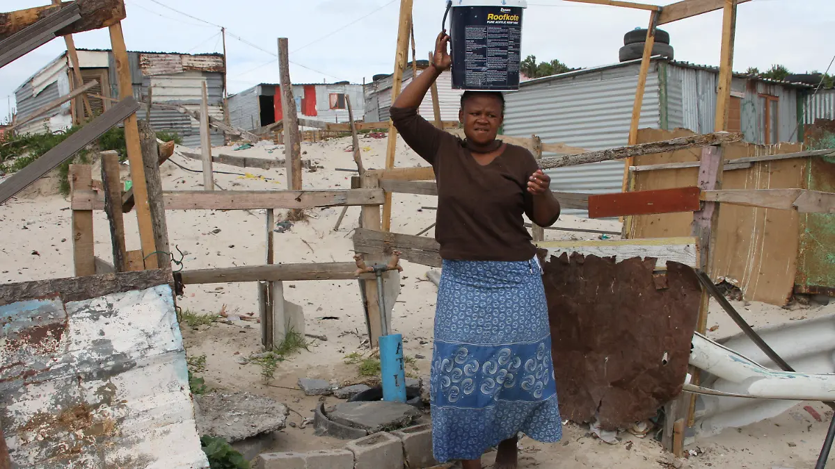ARCHIV - 09.02.2018, Afrika, Kapstadt, Khayelitsha: Mandla Qosholo, 25, die im südafrikanischen Armenviertel Khayelitsha, außerhalb von Kapstadt lebt, muss täglich Wasser in 25-Liter-Eimern von einem kommunalen Wasserhahn in ihre Hütte ohne Küche und Bad tragen. (zu dpa "Ernüchterung in Südafrika trotz Mandelas historischer Verdienste" am 17.07.2018) Foto: Kristin Palitza/dpa +++ dpa-Bildfunk +++