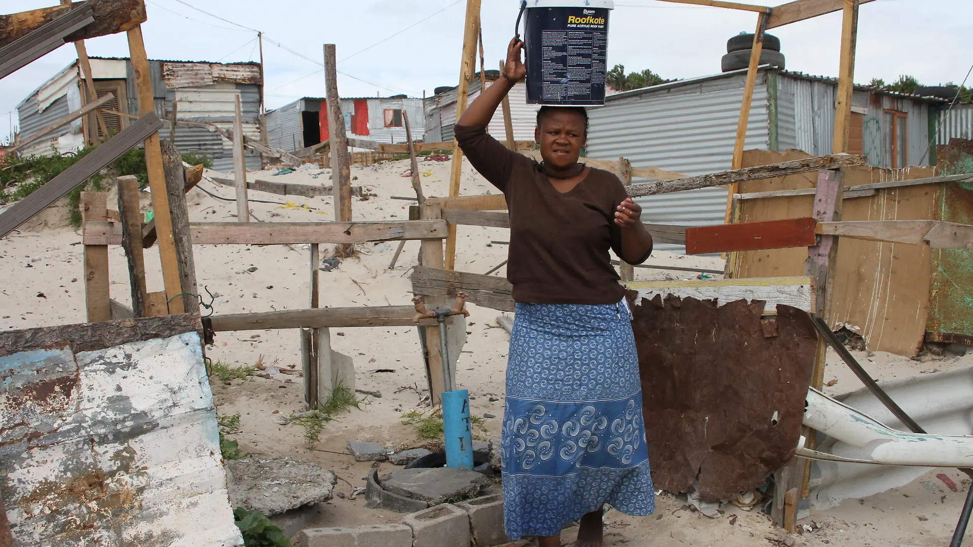 ARCHIV - 09.02.2018, Afrika, Kapstadt, Khayelitsha: Mandla Qosholo, 25, die im südafrikanischen Armenviertel Khayelitsha, außerhalb von Kapstadt lebt, muss täglich Wasser in 25-Liter-Eimern von einem kommunalen Wasserhahn in ihre Hütte ohne Küche und Bad tragen. (zu dpa "Ernüchterung in Südafrika trotz Mandelas historischer Verdienste" am 17.07.2018) Foto: Kristin Palitza/dpa +++ dpa-Bildfunk +++