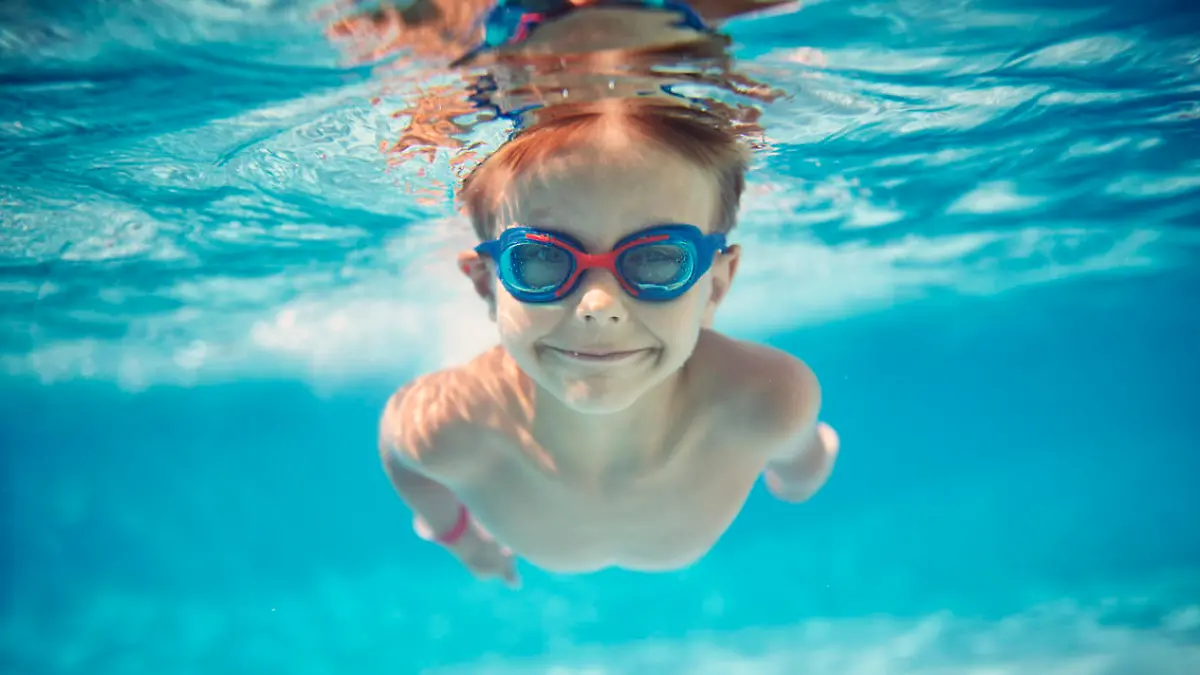Kind taucht beim Schwimmen