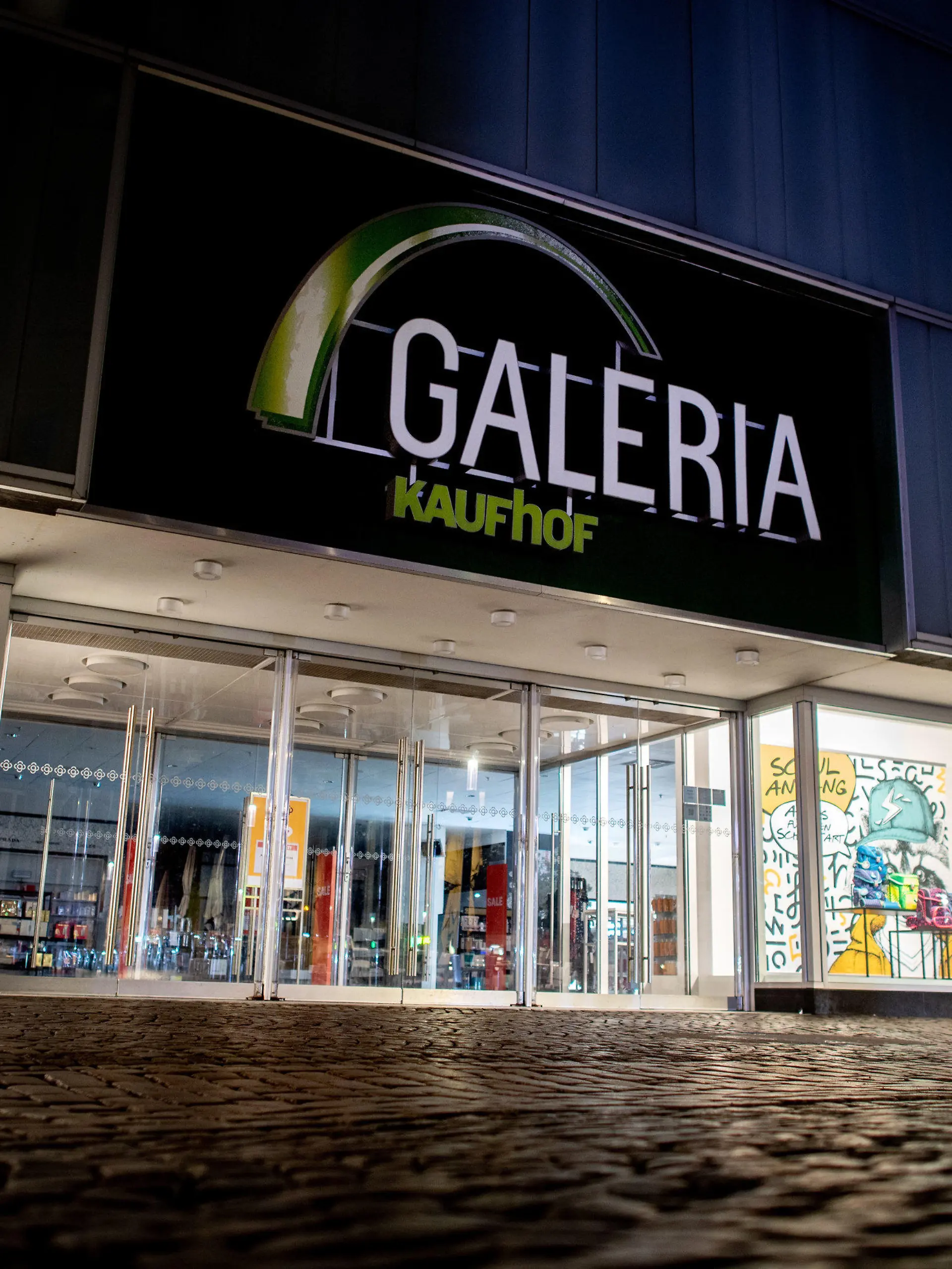 ARCHIV - 22.02.2023, Niedersachsen, Oldenburg: Ein Logo hängt an einer Filiale von Galeria Karstadt Kaufhof in der Innenstadt von Oldenburg. (Zu dpa «Rettung oder Schließung - Wie es um die Galeria-Standorte steht») Foto: Hauke-Christian Dittrich/dpa +++ dpa-Bildfunk +++