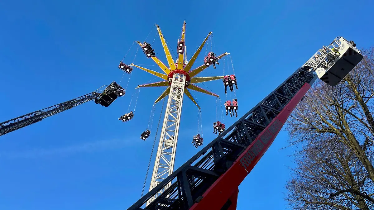 11.03.2023, Nordrhein-Westfalen, Halle: Menschen werden wegen eines Defekts in einem Kettenkarussell auf einer Kirmes in Halle (Westfalen) von der Feuerwehr mit Leiterwagen gerettet. Die letzten Mitfahrer konnten am Samstagnachmittag nach rund 75 Minuten zu Boden befördert werden, sagte ein Polizeisprecher. (Zu dpa «24 Menschen harren in Kettenkarussell aus ») Foto: Christian Müller/Westfalennews/dpa +++ dpa-Bildfunk +++
