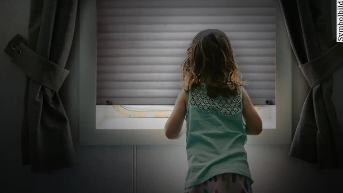 Mädchen vor geschlossenem Fenster (Symbolbild).