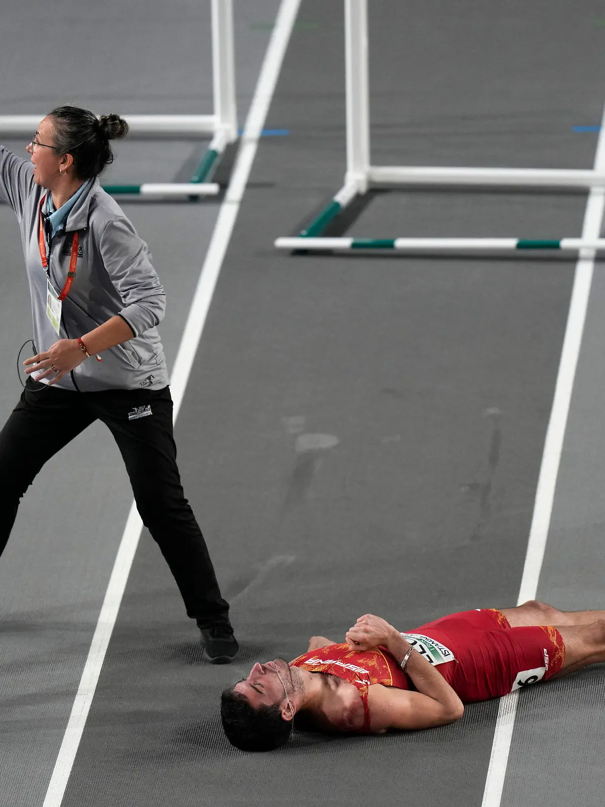 dpatopbilder - 05.03.2023, Türkei, Istanbul: Leichtathletik/Halle: Europameisterschaft, Männer 60 Meter Hürden, Finale: Hilfe wird gerufen, nachdem Enrique Llopis aus Spanien während Finales gestürzt und mit dem Kopf auf den Boden aufgeschlagen ist. Nach der Behandlung wurde Llopis auf einer Trage aus der Halle gebracht. Foto: Khalil Hamra/AP +++ dpa-Bildfunk +++