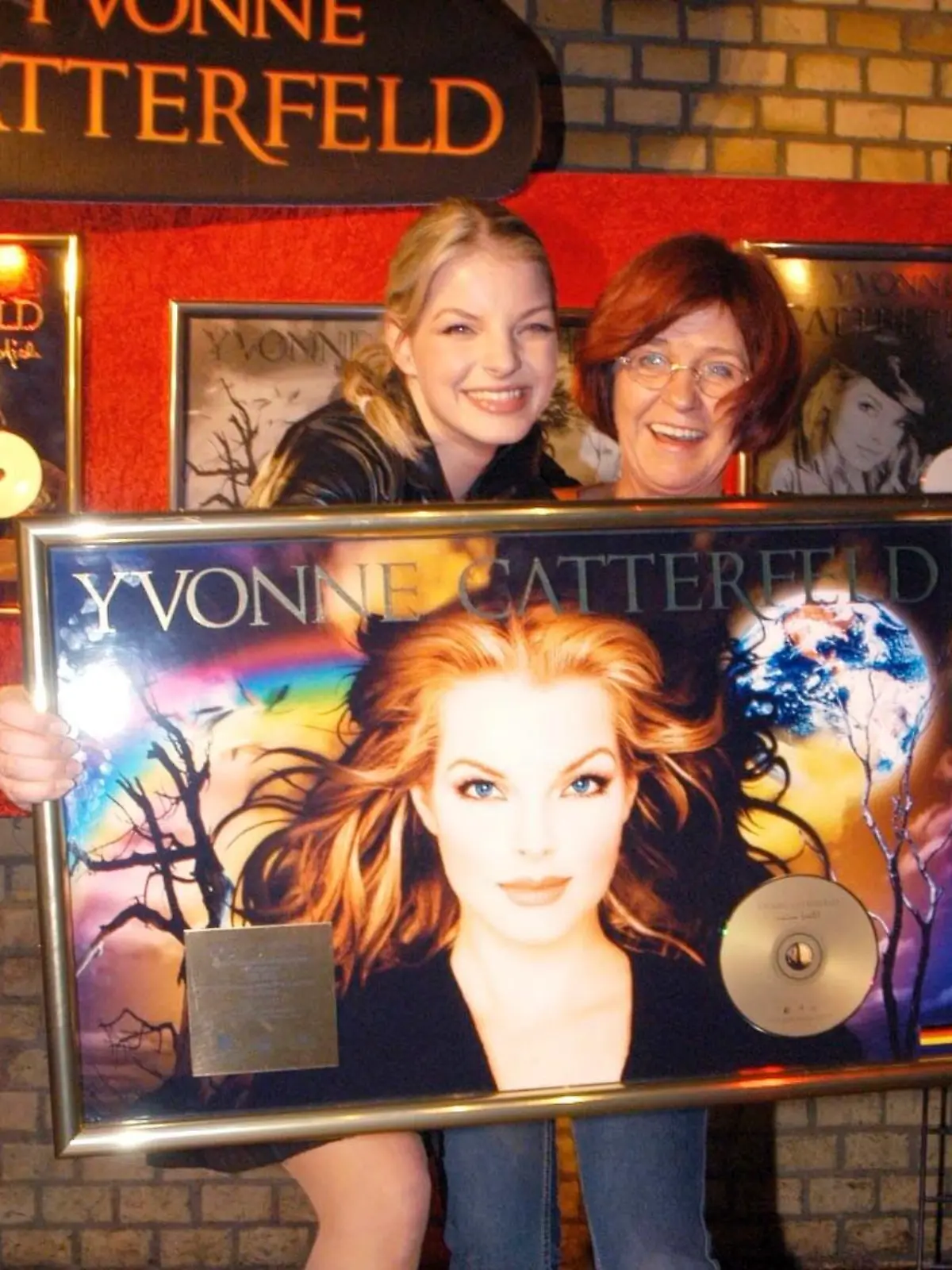 Yvonne Catterfeld bekommt Gold und Platin?Eventpress / Mathias Krohn               Datum : 28.3.2004?Thema : Yvonne Catterfeld und ihre Managerin Veronika Jarzombek . Bei der Aftershowparty ihres letzten Konzerts ihrer Deutschlandtournee im "Dante" am Hackeschen Markt in Berlin, bekam Yvonne Catterfeld  Gold und Platin für ihr Album "Meine Welt" und den Song "Für Dich".ueberreicht wurde die Auszeichnung von BMG-Chef Andre Selleneit .