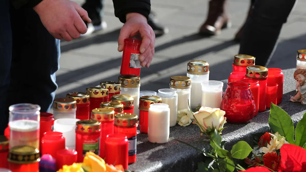 09.12.2019, Bayern, Augsburg: Ein Mann plaziert ein Grablicht an einem Rondell am Königsplatz. Ein Feuerwehrmann war am Freitagabend (06.12.2019) hier in seiner Freizeit nach einem Schlag so schwer verletzt worden, dass er noch vor Ort starb. Foto: Karl-Josef Hildenbrand/dpa +++ dpa-Bildfunk +++