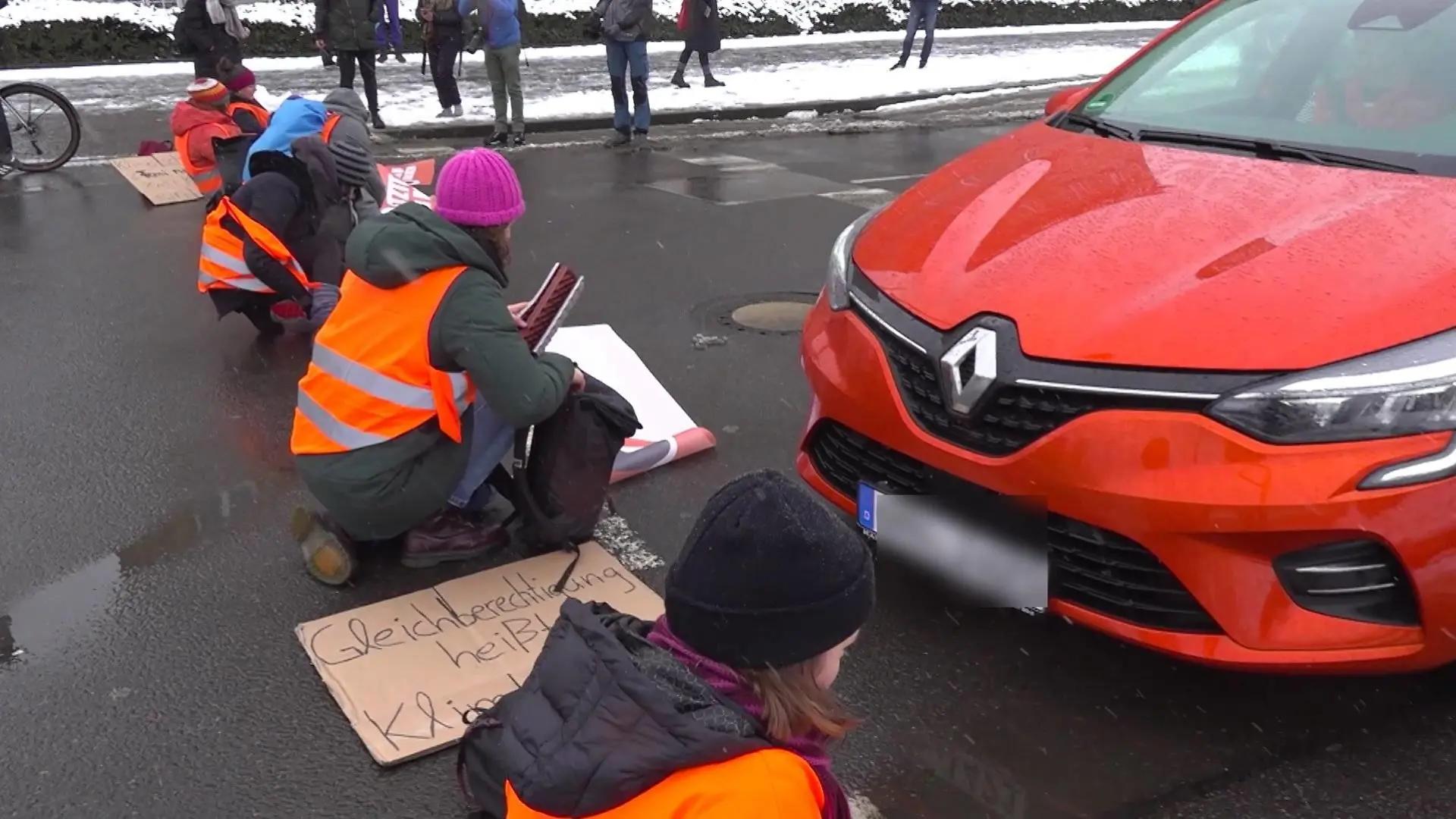Ein Autofahrer soll einer Klimakleberin über den Fuß gefahren sein.