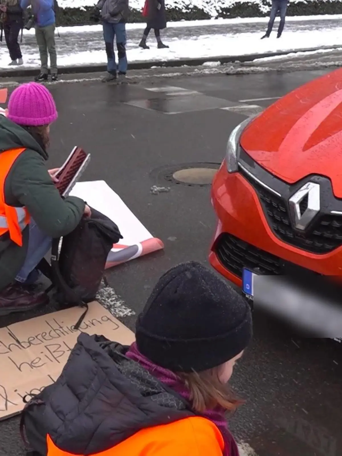 Ein Autofahrer soll einer Klimakleberin über den Fuß gefahren sein.