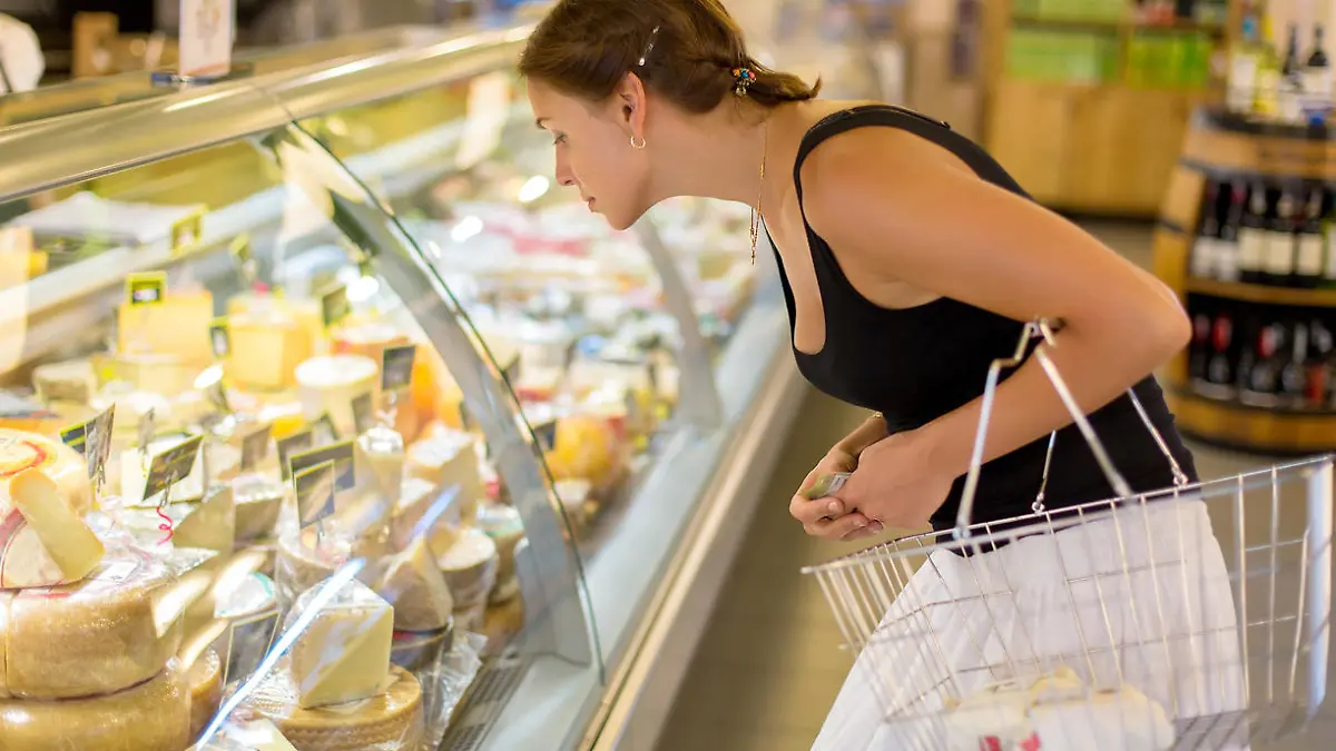 woman buys cheese in the supermarket