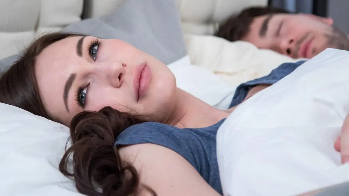 ILLUSTRATION - Eine junge Frau liegt am 24.03.2017 in Hamburg neben ihrem Partner wach im Bett (gestellte Szene). Foto: Christin Klose