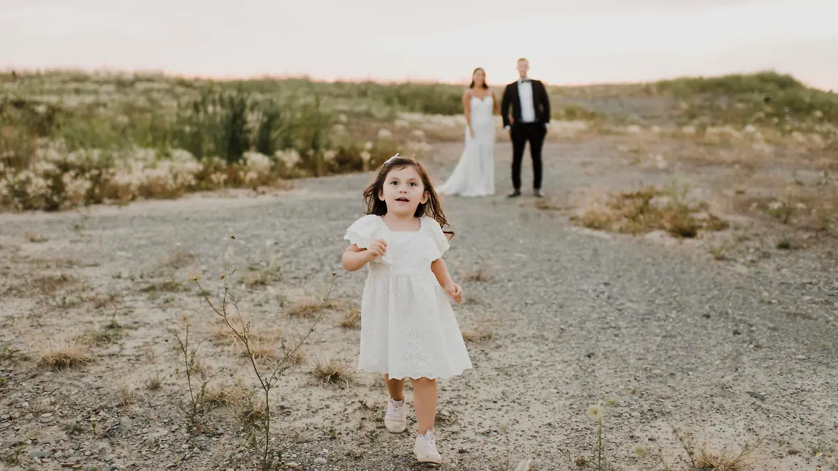 Cute daughter running while parents standing against sky || Modellfreigabe vorhanden