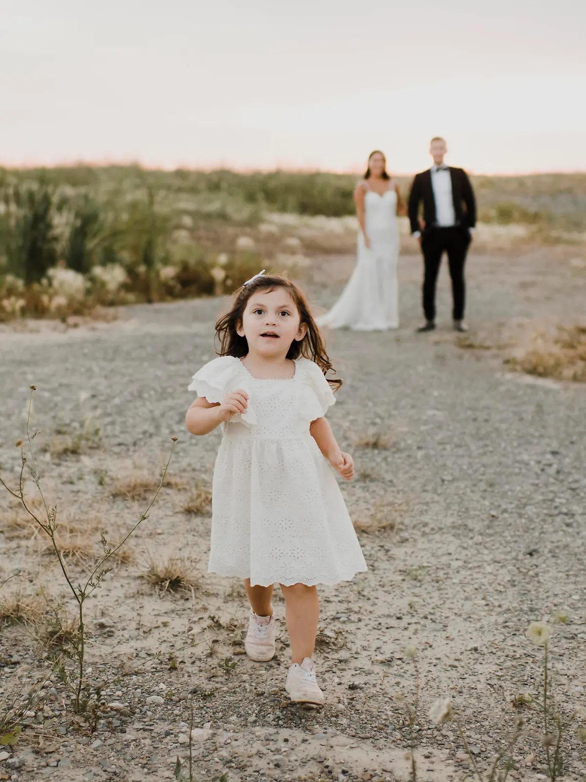 Cute daughter running while parents standing against sky || Modellfreigabe vorhanden