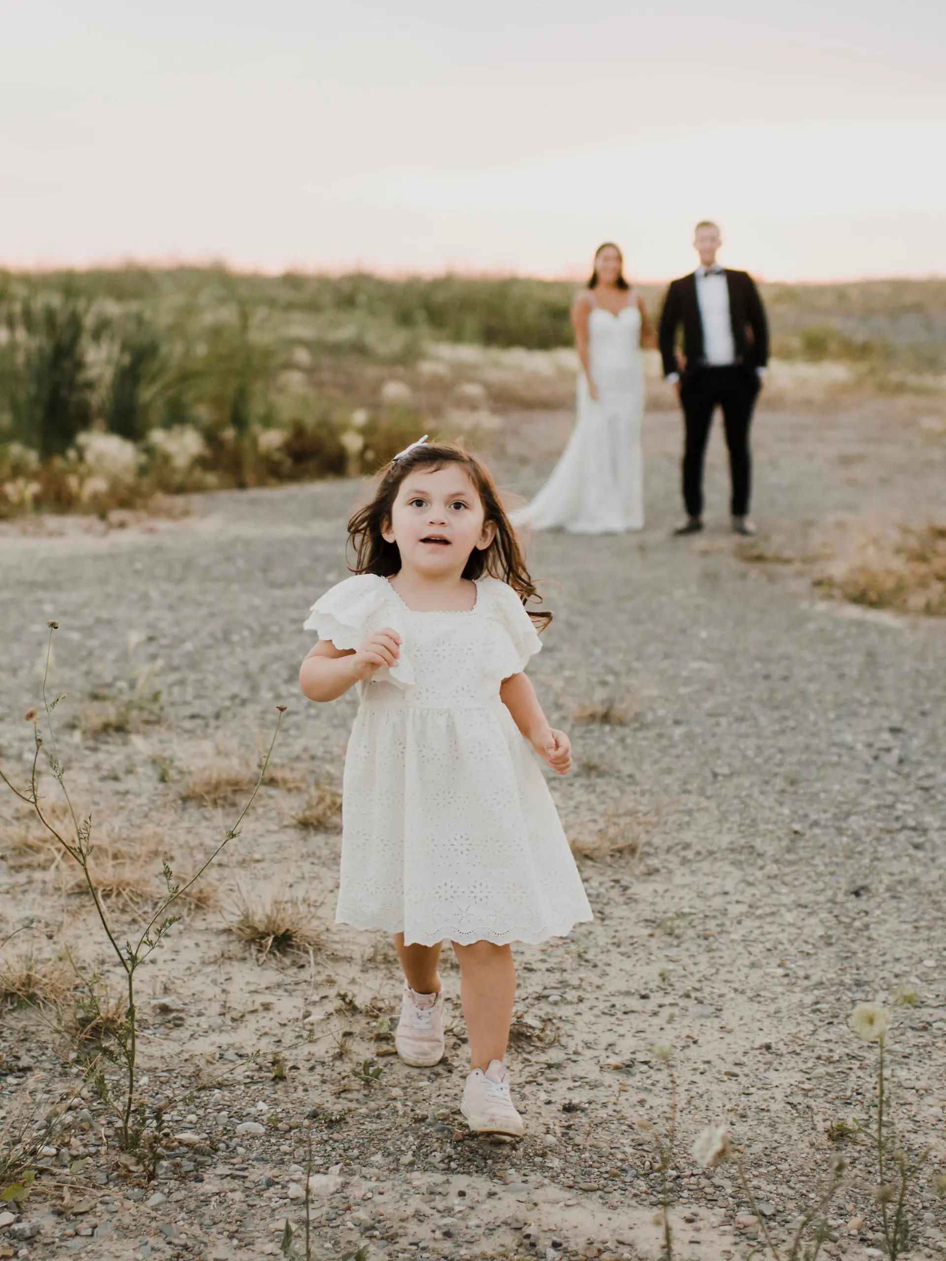 Cute daughter running while parents standing against sky || Modellfreigabe vorhanden
