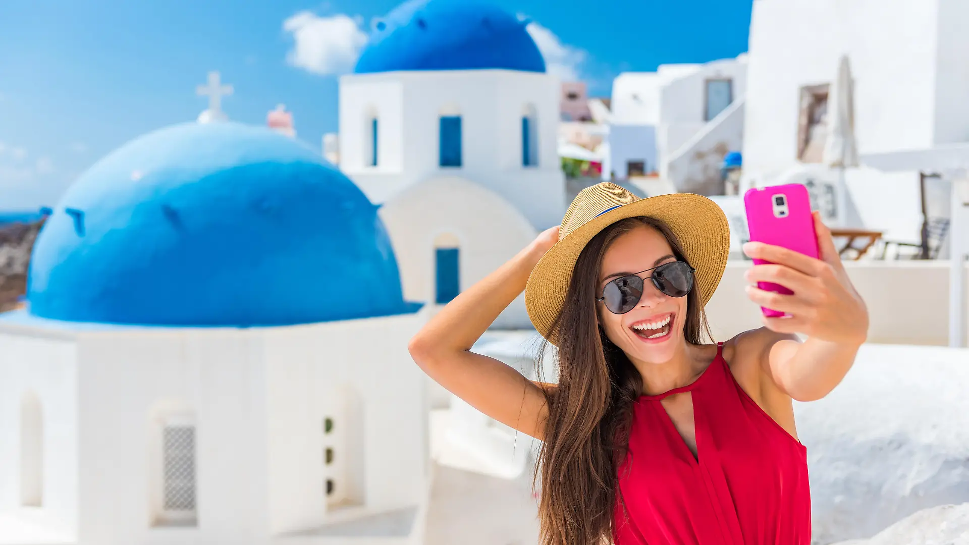 Santorini travel selfie girl taking photo having fun on European cruise holidays. Summer destination.